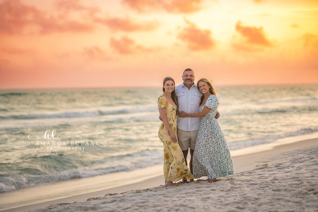 A family of four at the shoreline in soft pastel light during a Fort De Soto family photography session