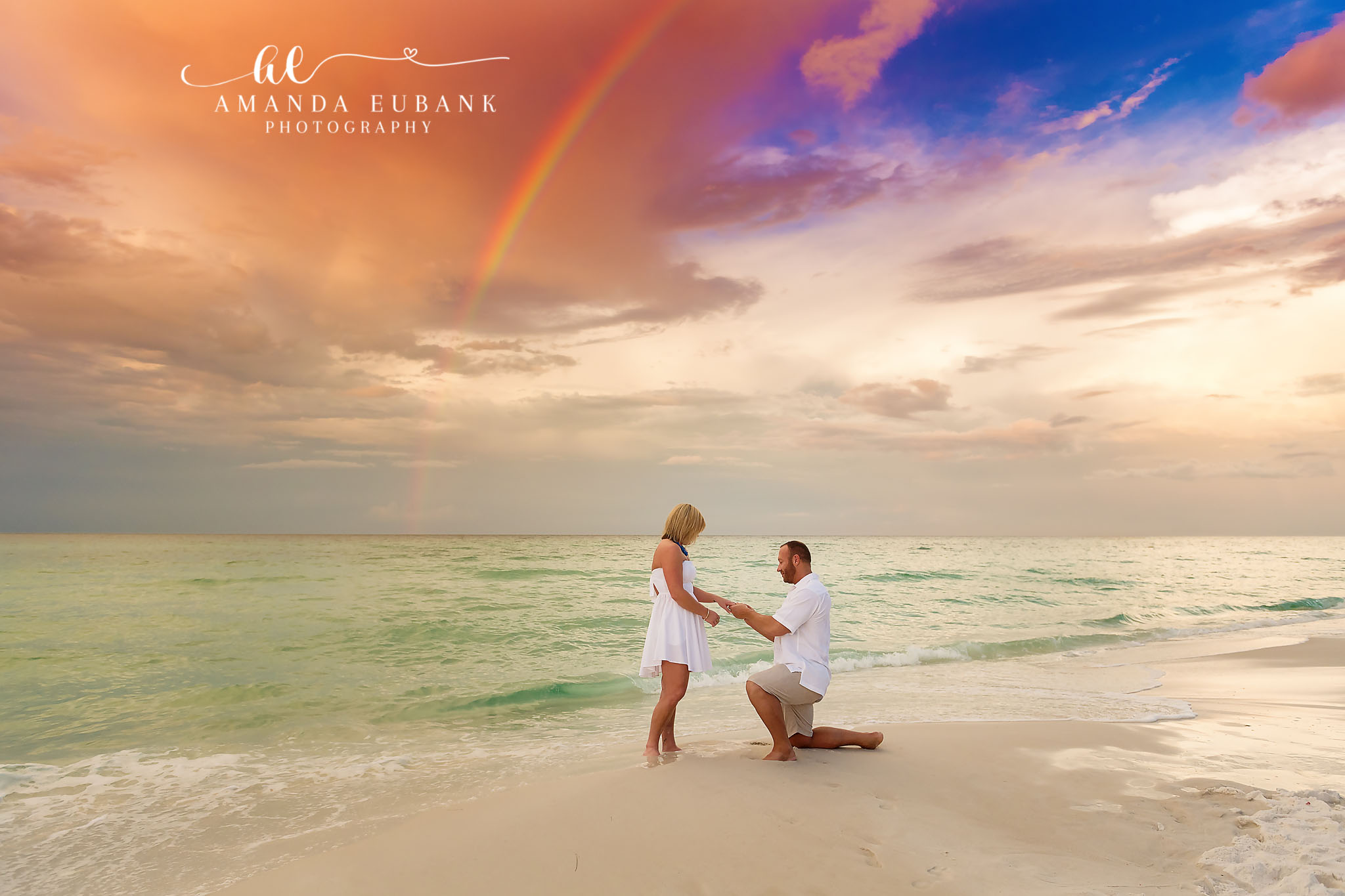 Sunset Beach Proposal Under a Rainbow | Tampa Engagement Photographer A marriage proposal on the sand as a rainbow arches over the Gulf at sunset during a Tampa engagement photography session.