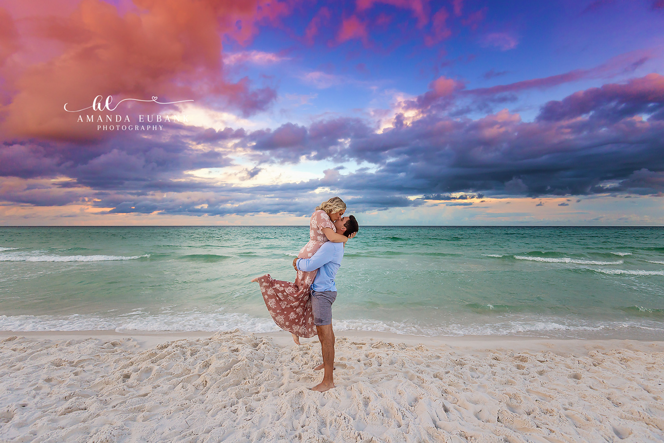 Storm Clouds and a Sunset Lift | Tampa Engagement Photographer A man lifting his fiancee as storm clouds break open over the Gulf during a Tampa engagement photography session.
