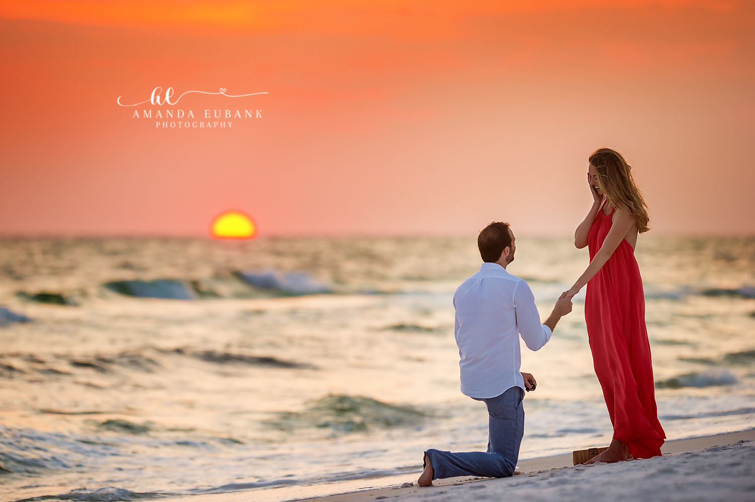 Proposal Silhouette at Sundown | Engagement Photographer in Tampa, Florida Engagement photos in Tampa, FL showing the silhouette of a proposal as the sun touches the horizon behind a red gown.