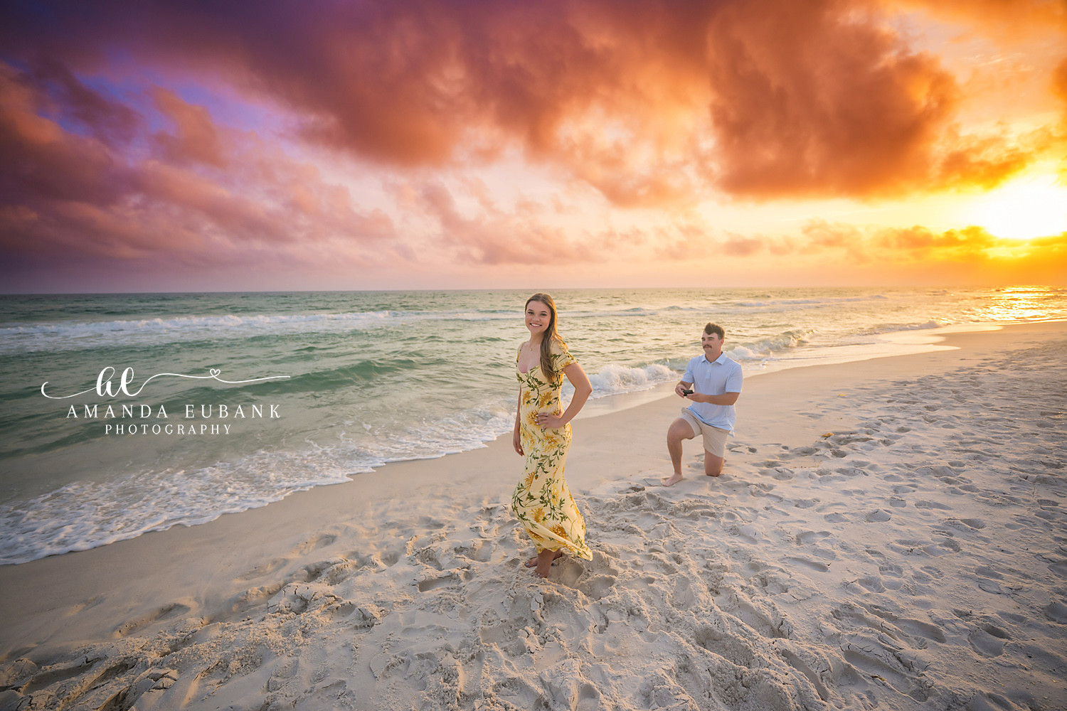 She Says Yes — Tampa, FL Engagement Session The moment she turns to find him on one knee with her yellow floral dress swirling at a Gulf beach engagement session near Tampa, Florida.