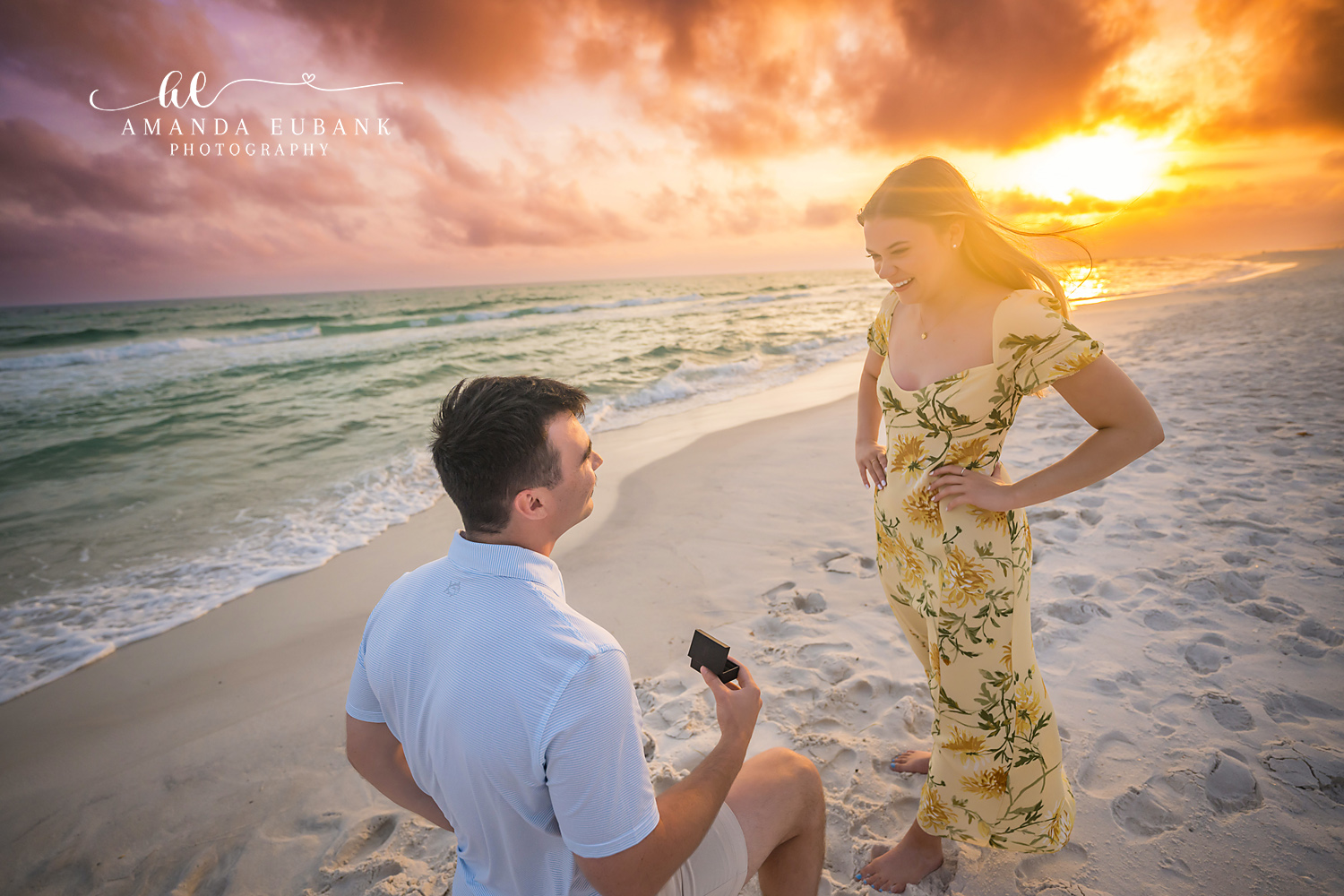 One Knee on the Shoreline | Engagement Photographer in Tampa, Florida Engagement photos in Tampa, FL showing a man on one knee with the ring box as the sun flares behind the dunes.