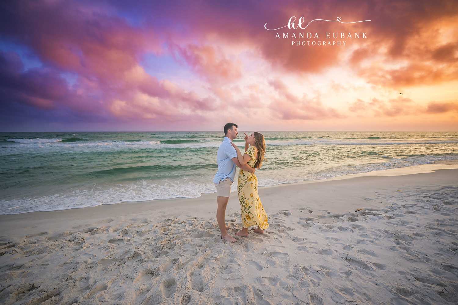 Hug on the Wet Sand | Tampa Engagement Photographer A couple holding each other on the wet sand under sweeping sunset clouds during a Tampa engagement photography session.