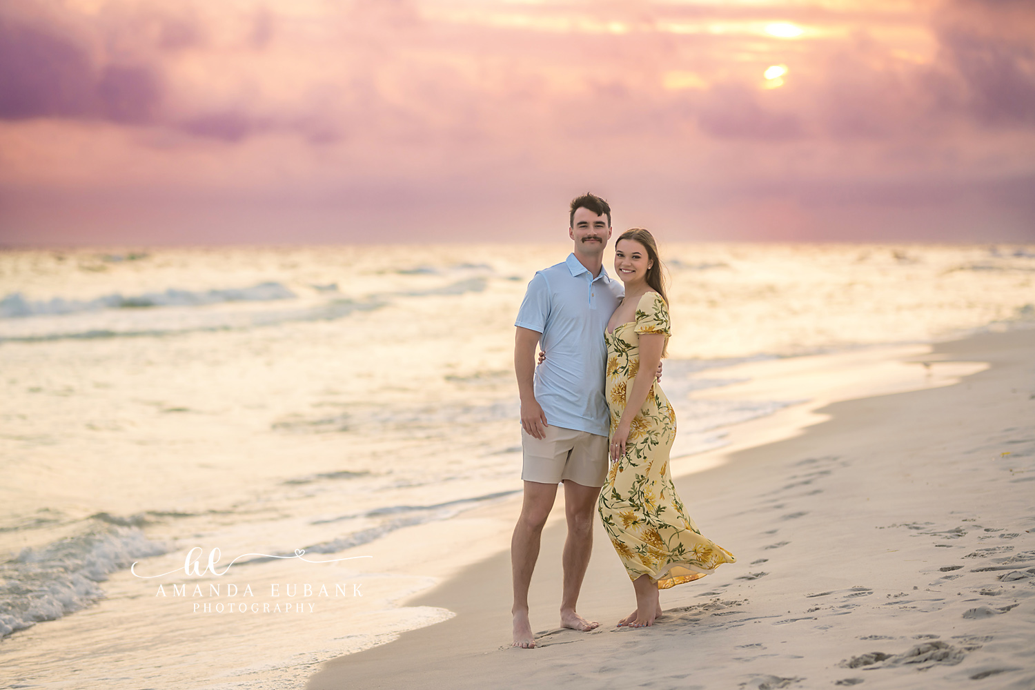 Arm in Arm in the Shallows — Tampa, FL Engagement Session A couple walking arm in arm through the shallow surf in soft pastel light at a Gulf beach engagement session near Tampa, Florida.