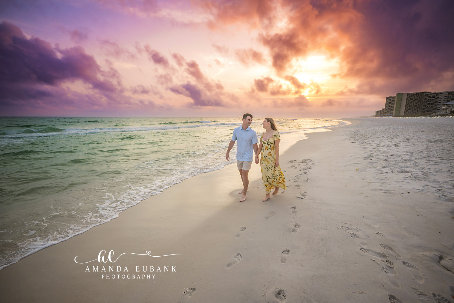Walking the Shoreline at Dusk | Engagement Photographer in Tampa, Florida Engagement photos in Tampa, FL showing a couple walking hand in hand down the shoreline with the coastline behind them.