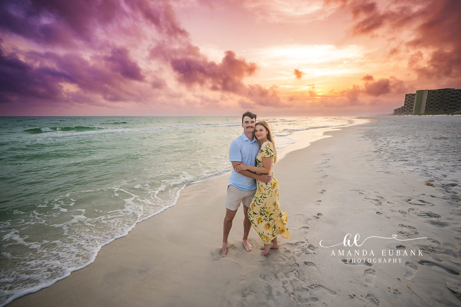 Close on the Wet Sand — Tampa, FL Engagement Session A couple standing close on the wet sand with purple light spread across the sky at a Gulf beach engagement session near Tampa, Florida.