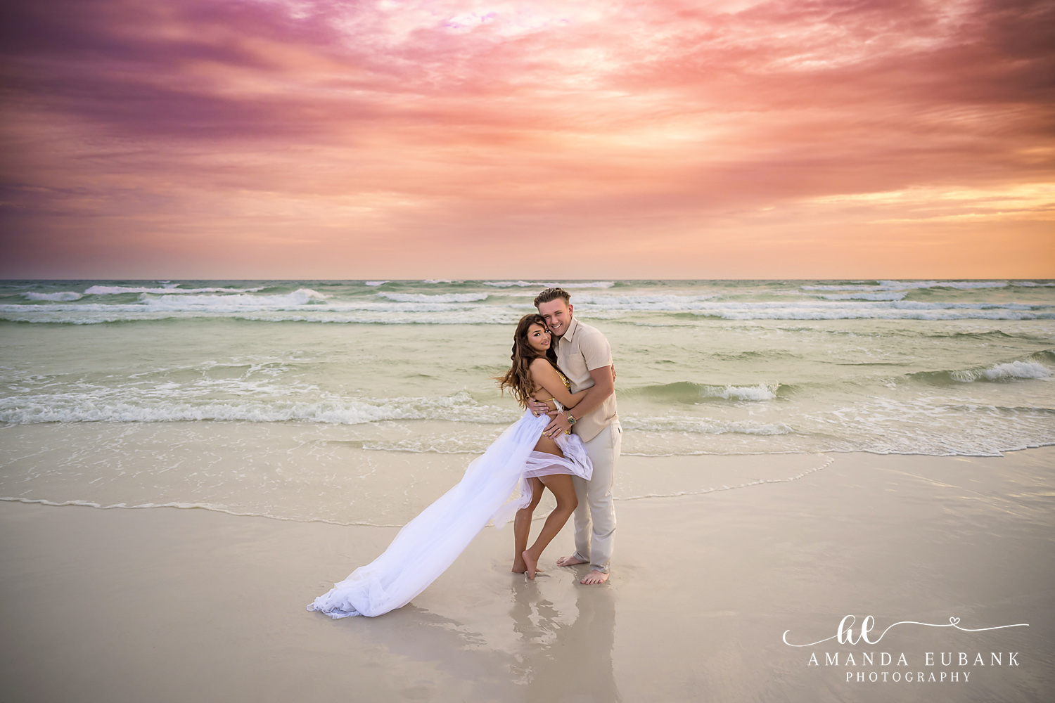Gown in the Surf | Tampa Engagement Photographer A couple in the surf with her long white gown swirling across the water during a Tampa engagement photography session.