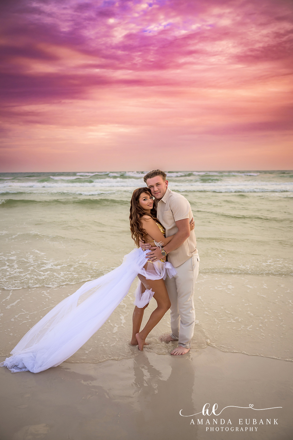 Flowing Train at Sunset | Tampa Beach Engagement Photography Tampa engagement photographer captures a couple embracing as her gown's train floats out across the shallow water.
