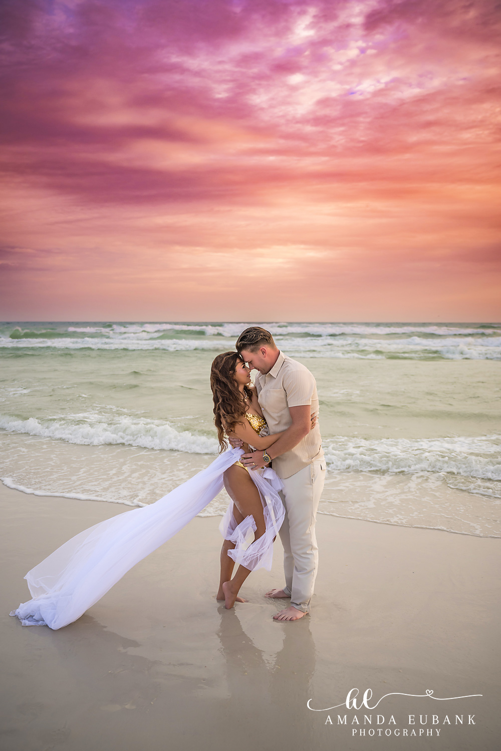 Kiss on the Wet Sand — Tampa, FL Engagement Session A couple kissing with her gown spread out behind them on the wet sand at a Gulf beach engagement session near Tampa, Florida.