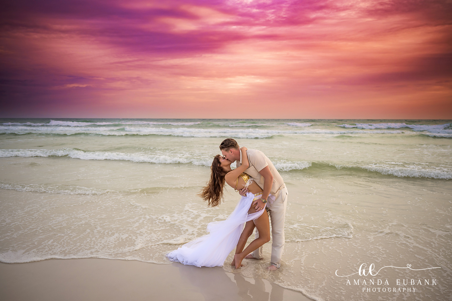 Dip Kiss in the Shallows | Engagement Photographer in Tampa, Florida Engagement photos in Tampa, FL showing a dip kiss in the shallows with her white gown trailing through the water.