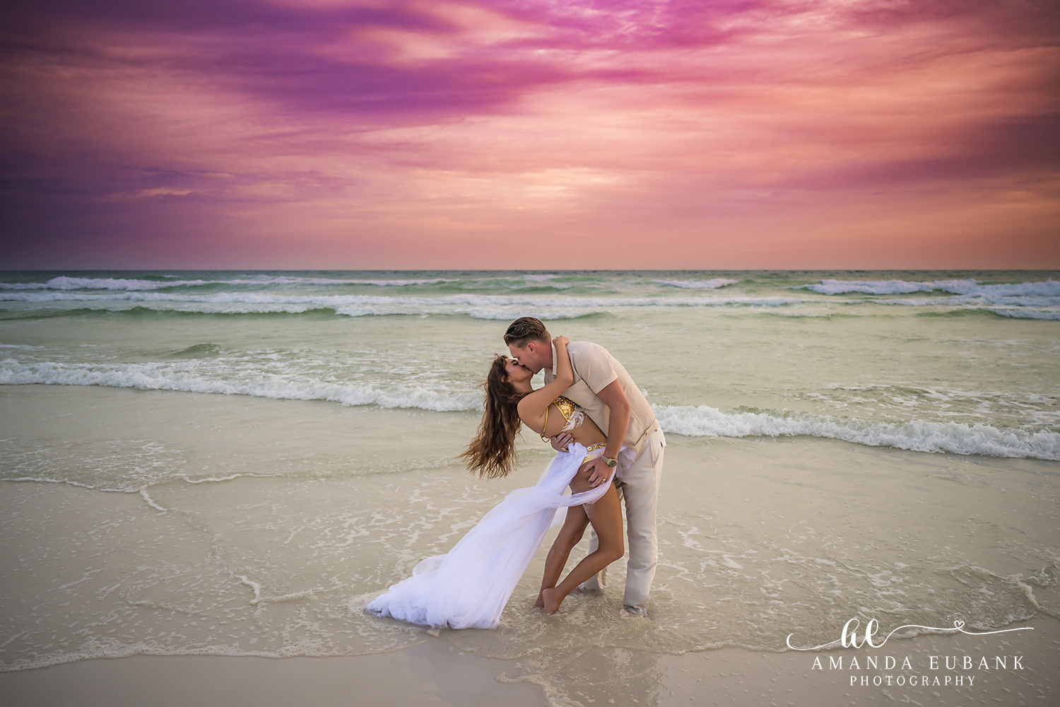 Low Dip Over the Surf — Tampa Bay Engagement Photography A low dip kiss just above the surf with her gown pooling in the water — beach engagement photography in Tampa Bay.