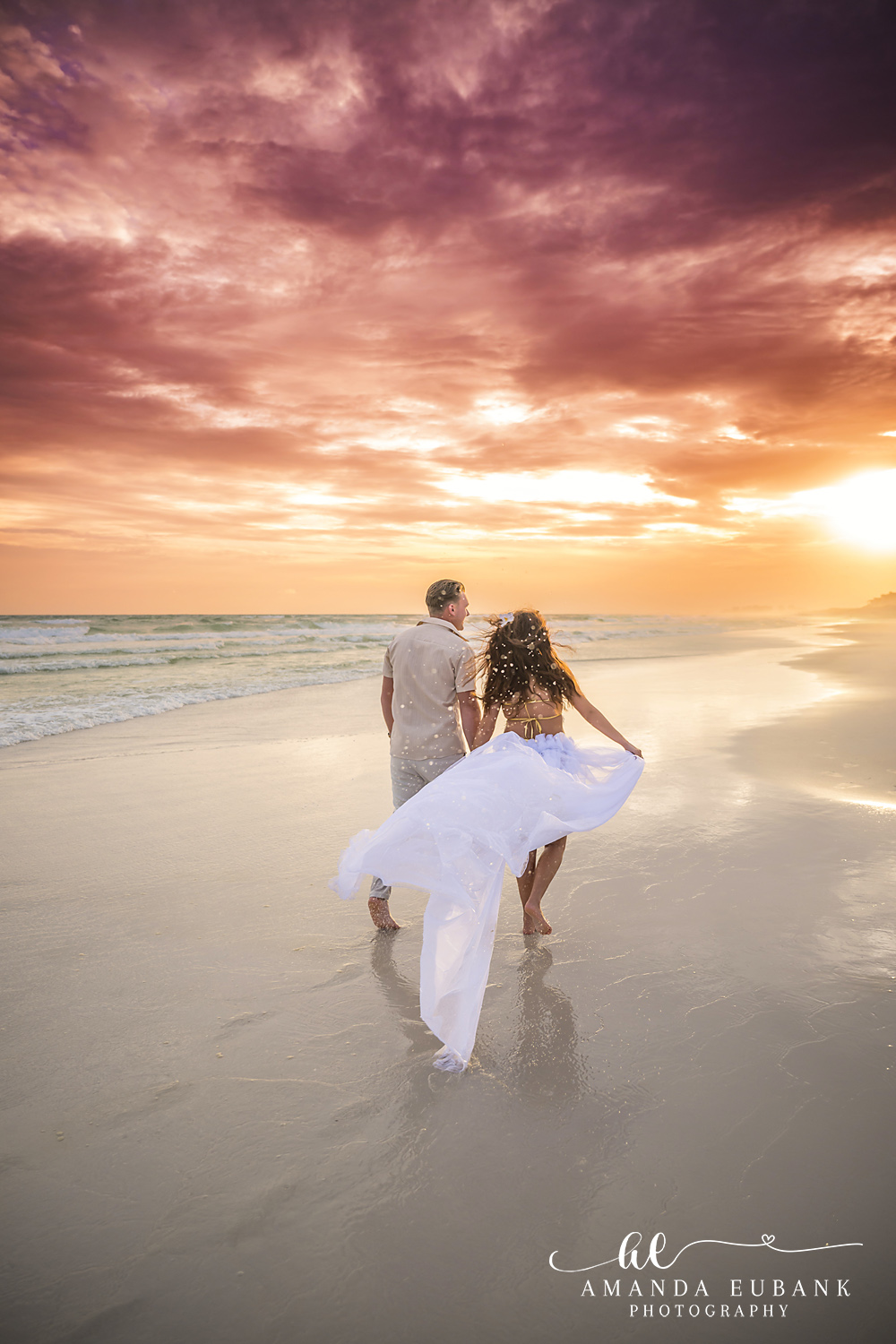 Dancing on Mirrored Sand — Tampa, FL Engagement Session A couple dancing on mirror-wet sand as the sun bursts along the horizon at a Gulf beach engagement session near Tampa, Florida.