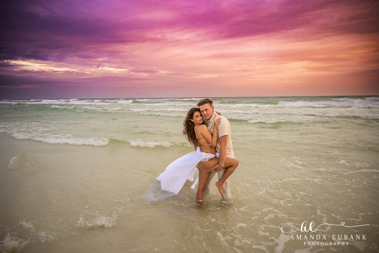 Kissing in the Shallow Water | Tampa Beach Engagement Photography Tampa engagement photographer captures a couple kissing low in the shallow water as her gown billows around them.