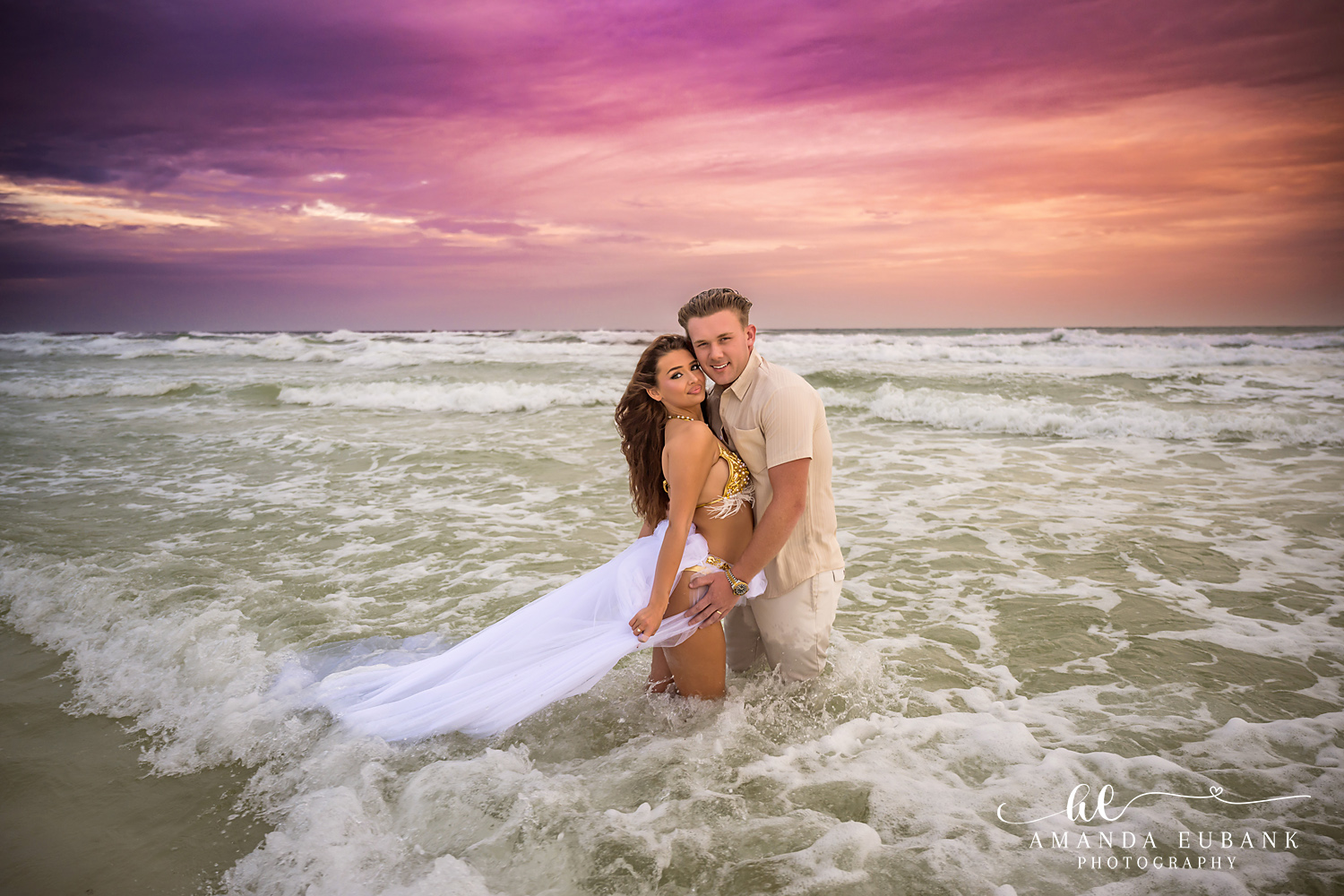 A Wave Rolls In | Tampa Engagement Photographer A wave rolling around a couple as her gown lifts with the water during a Tampa engagement photography session.