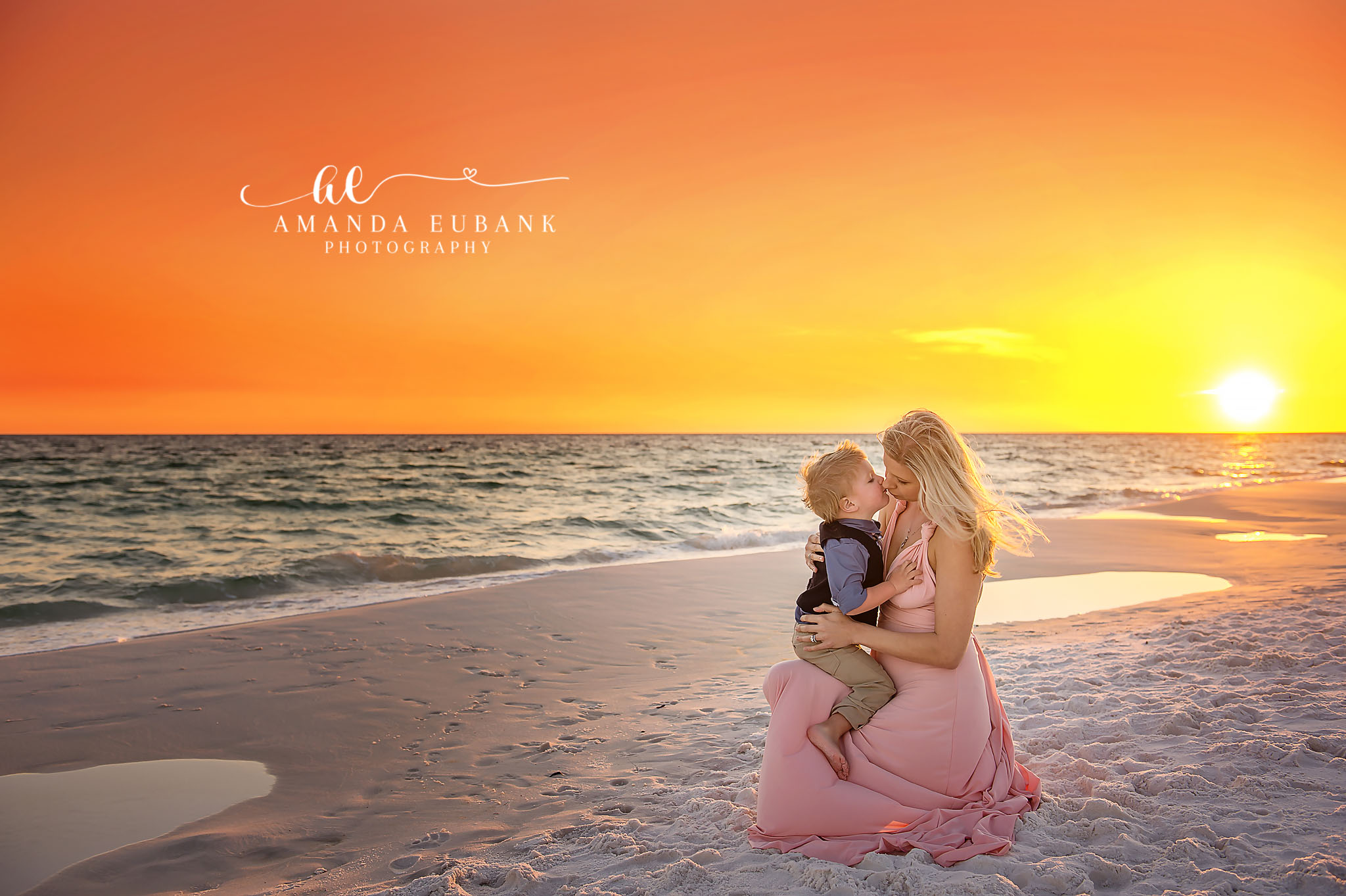 Mother and Son at Sunset | Family Photographer in Tampa, Florida Family beach portraits in Tampa, FL showing a mother in a blush gown holding her toddler son against a blazing orange sky.