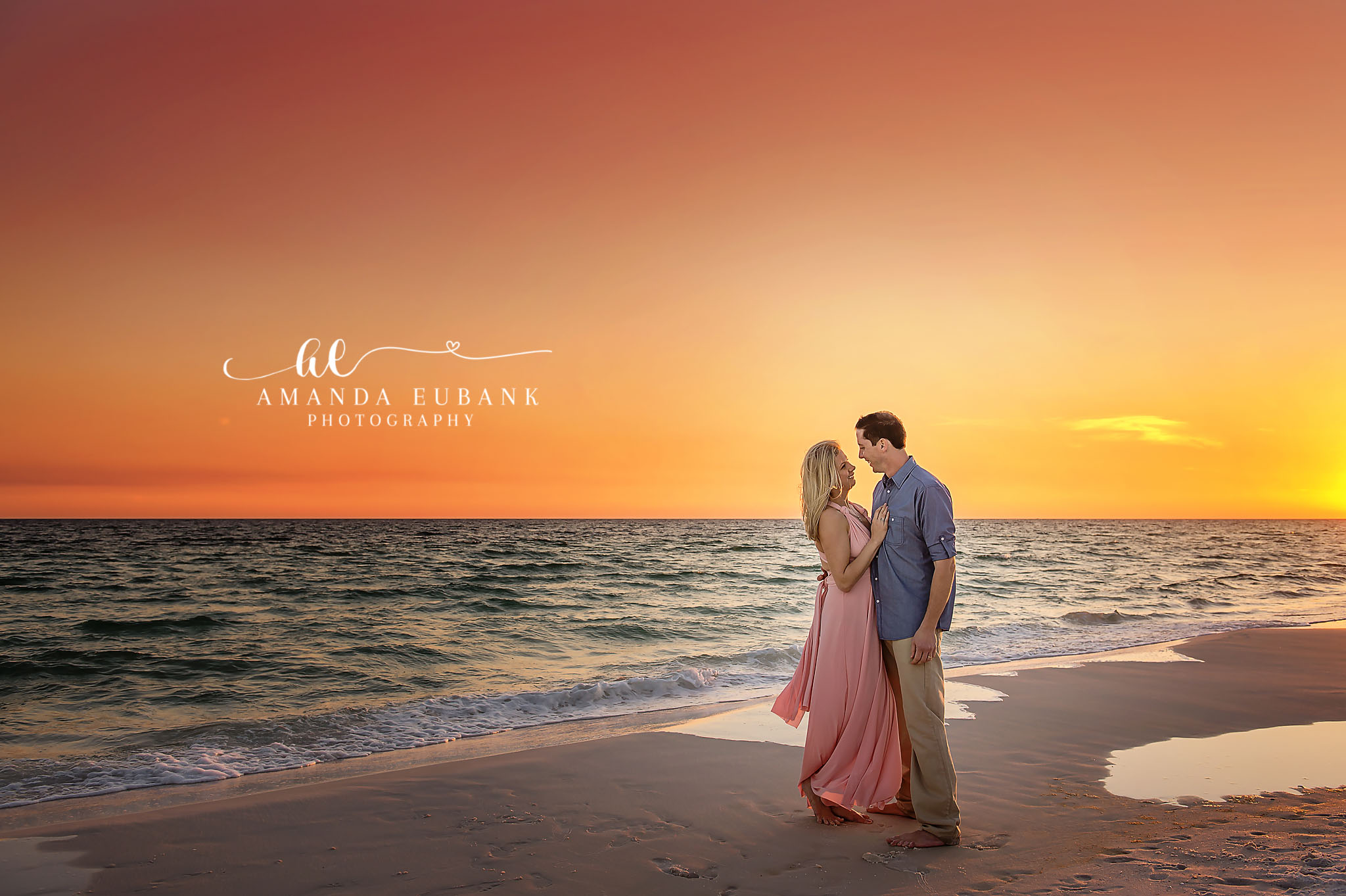 Blush Gown on the Shoreline — Tampa Bay Couples Portraits A couple standing on the shoreline in blush and blue as the sky turns orange — beach couples photography in Tampa Bay.