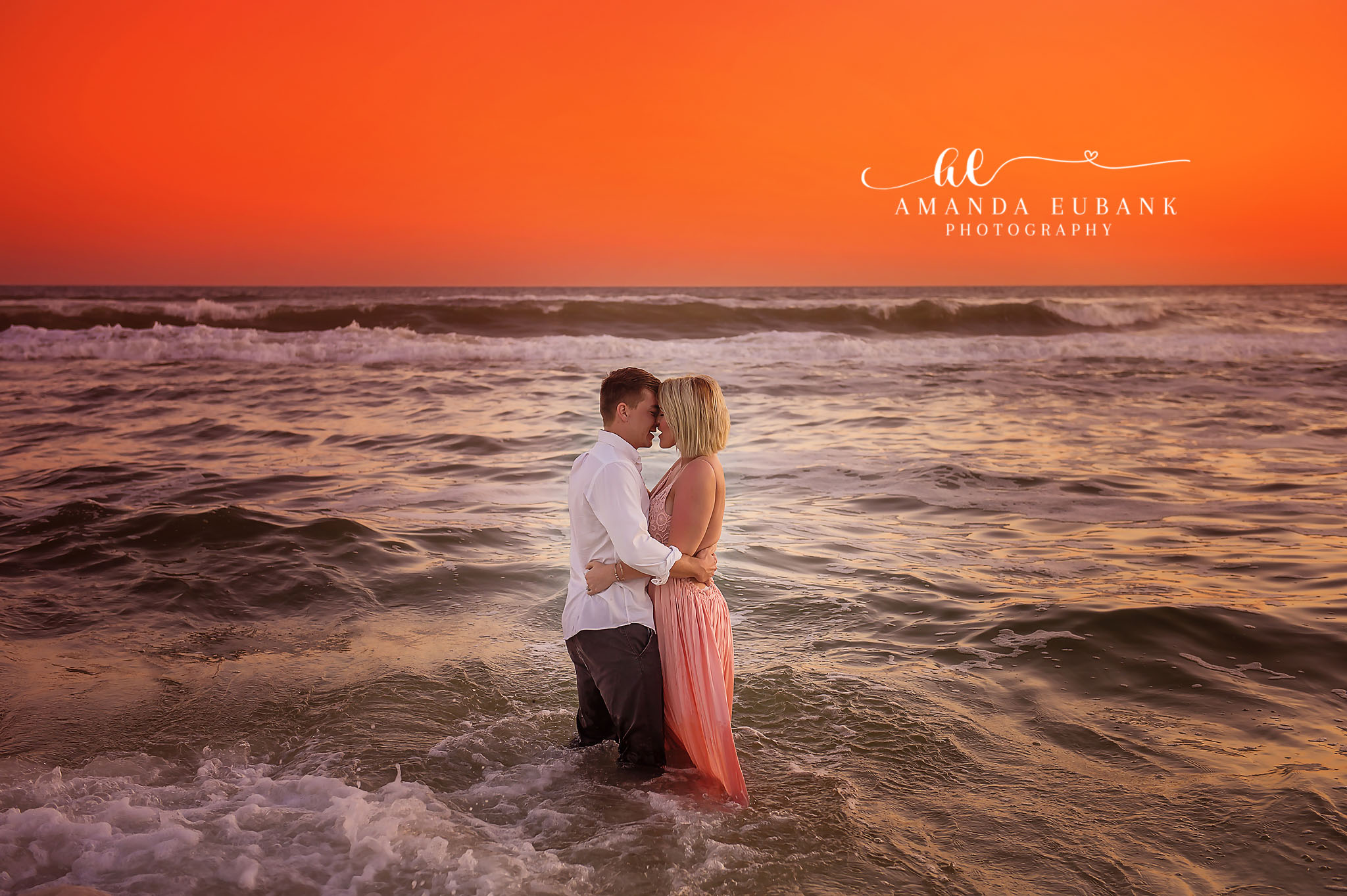 Beach Maternity Moment — Tampa, FL Maternity Session An expectant couple in the surf with his hands resting on her belly at sunset at a beach maternity session near Tampa, Florida.