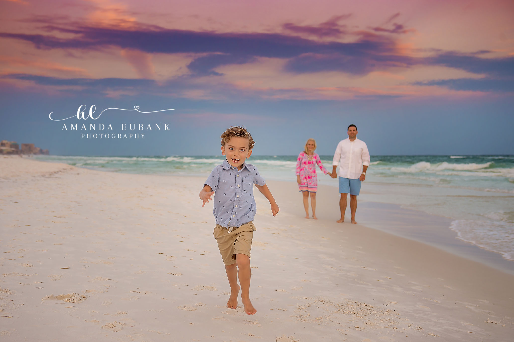 Running Down the Beach — Tampa Bay Children’s Photography A little boy running toward the camera with his family behind him on the sand at a beach kids session in Tampa, FL.