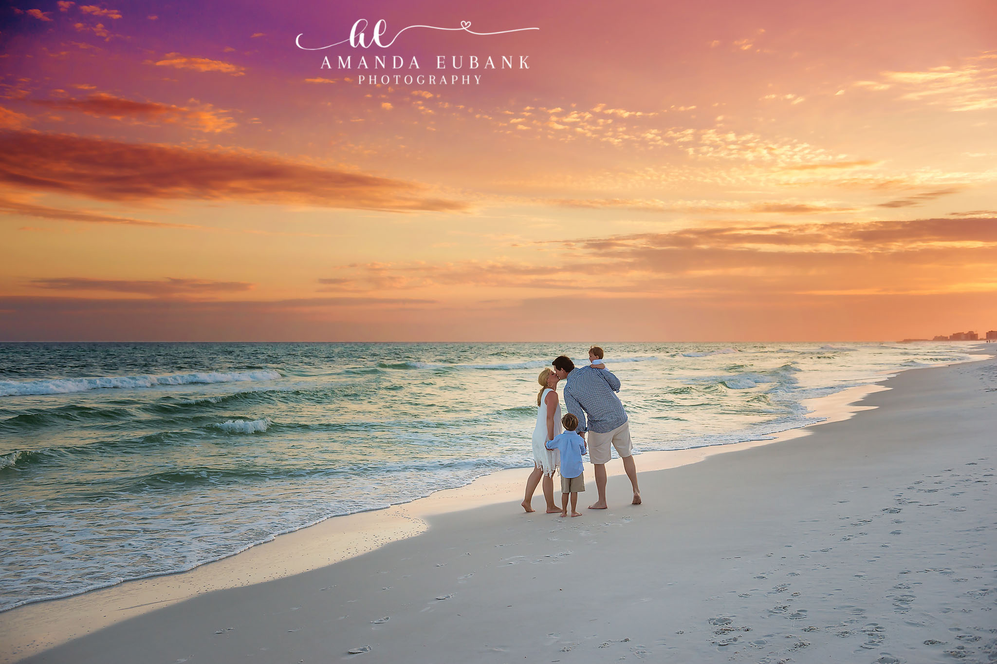 Family on a Wide Empty Beach | Family Photographer in Tampa, Florida Family beach portraits in Tampa, FL showing a family of four small in the frame on a wide empty beach at pastel sunset.
