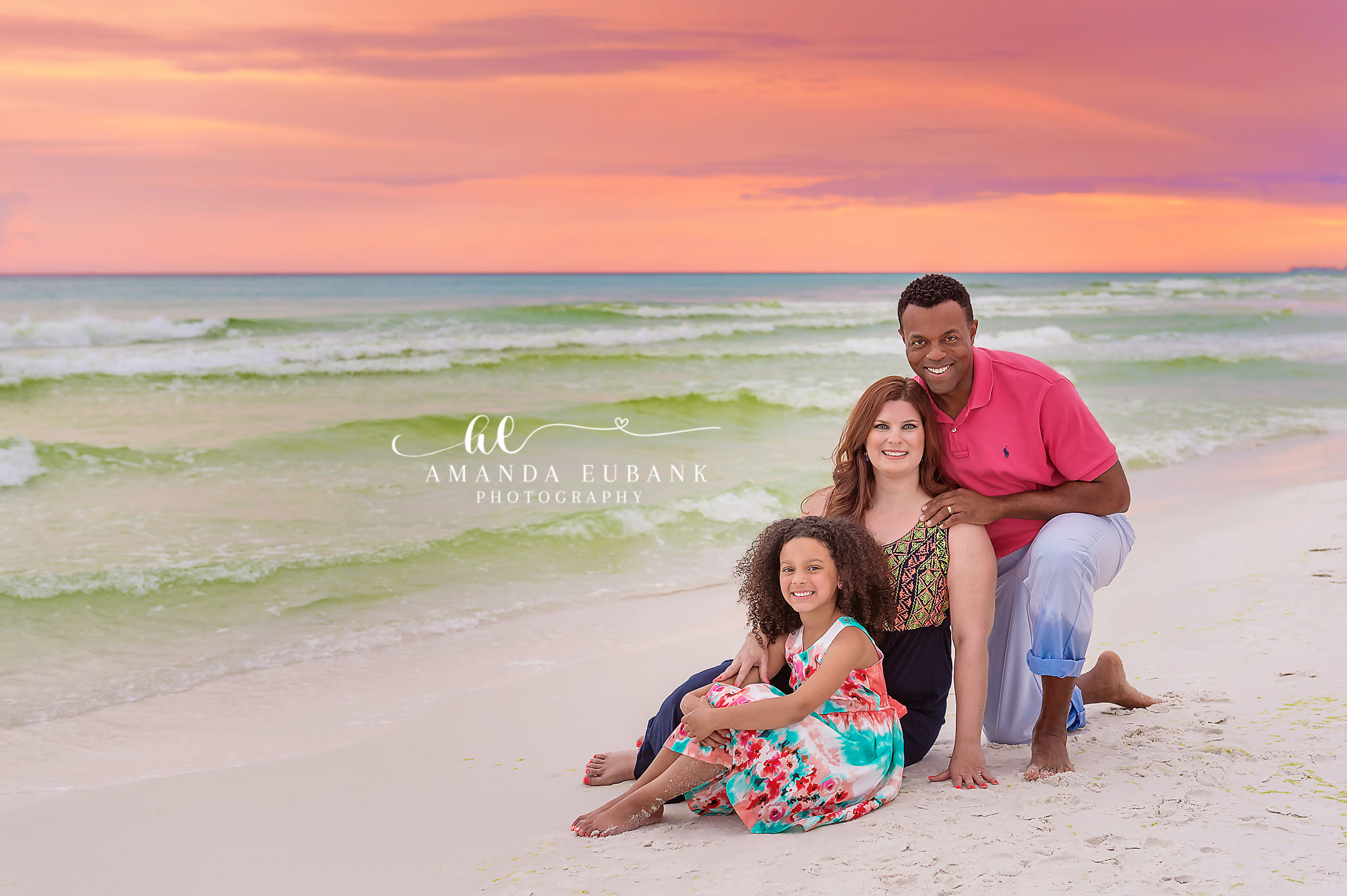 Family Portrait on White Sand — Tampa, FL Family Session A family of four sitting on white sand with the emerald Gulf behind them at a beach family session near Tampa, Florida.