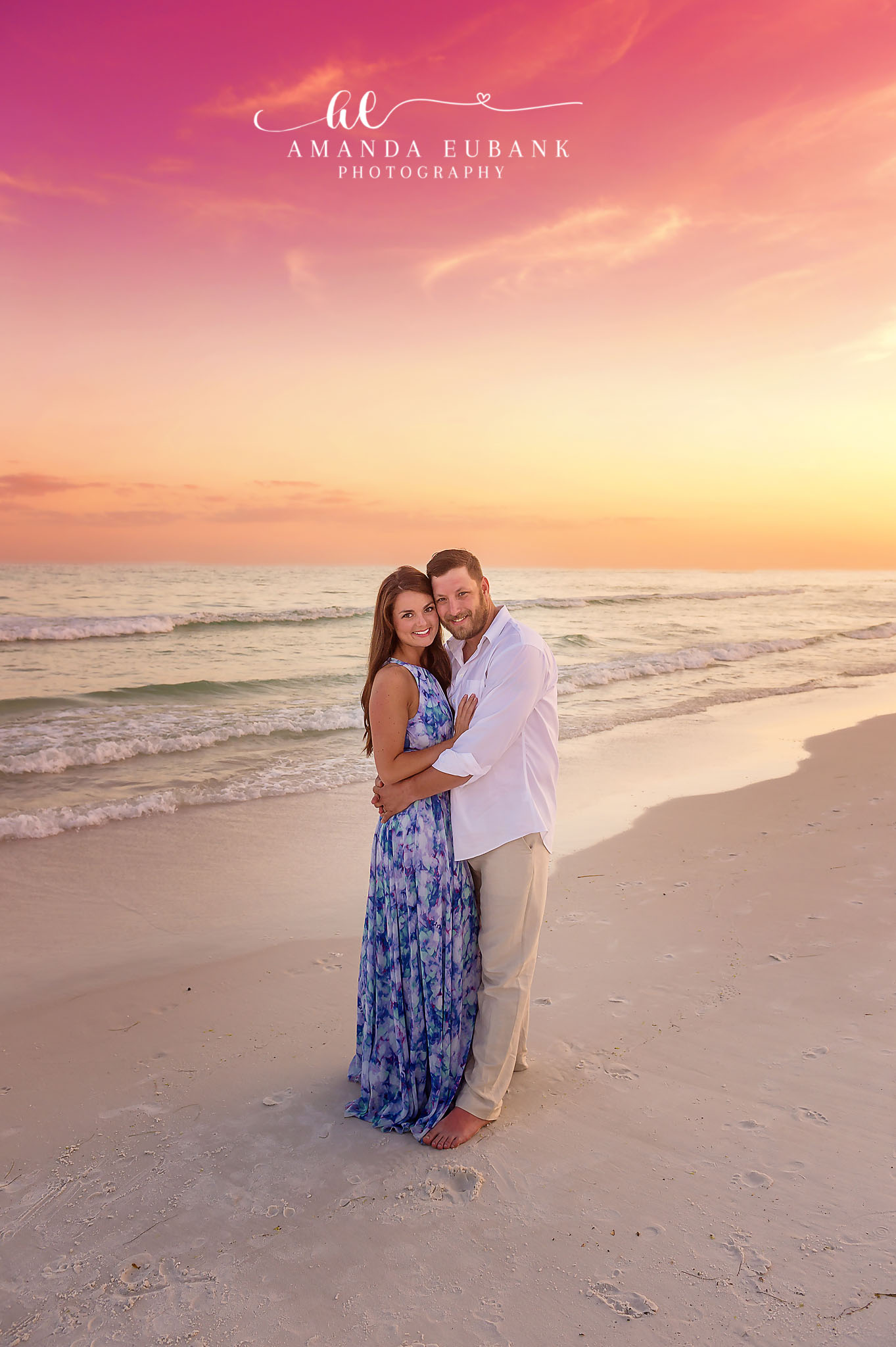 Couple at the Water’s Edge | Tampa Couples Photographer A couple embracing at the water's edge with her blue maxi dress catching the light during a Tampa couples photography session.