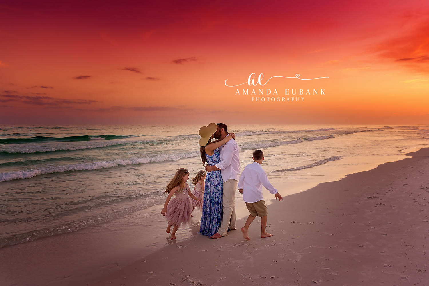 Holding Hands on Wet Sand | Tampa Beach Family Photography Tampa family photographer captures a family holding hands on the wet sand as the sky burns red and orange.