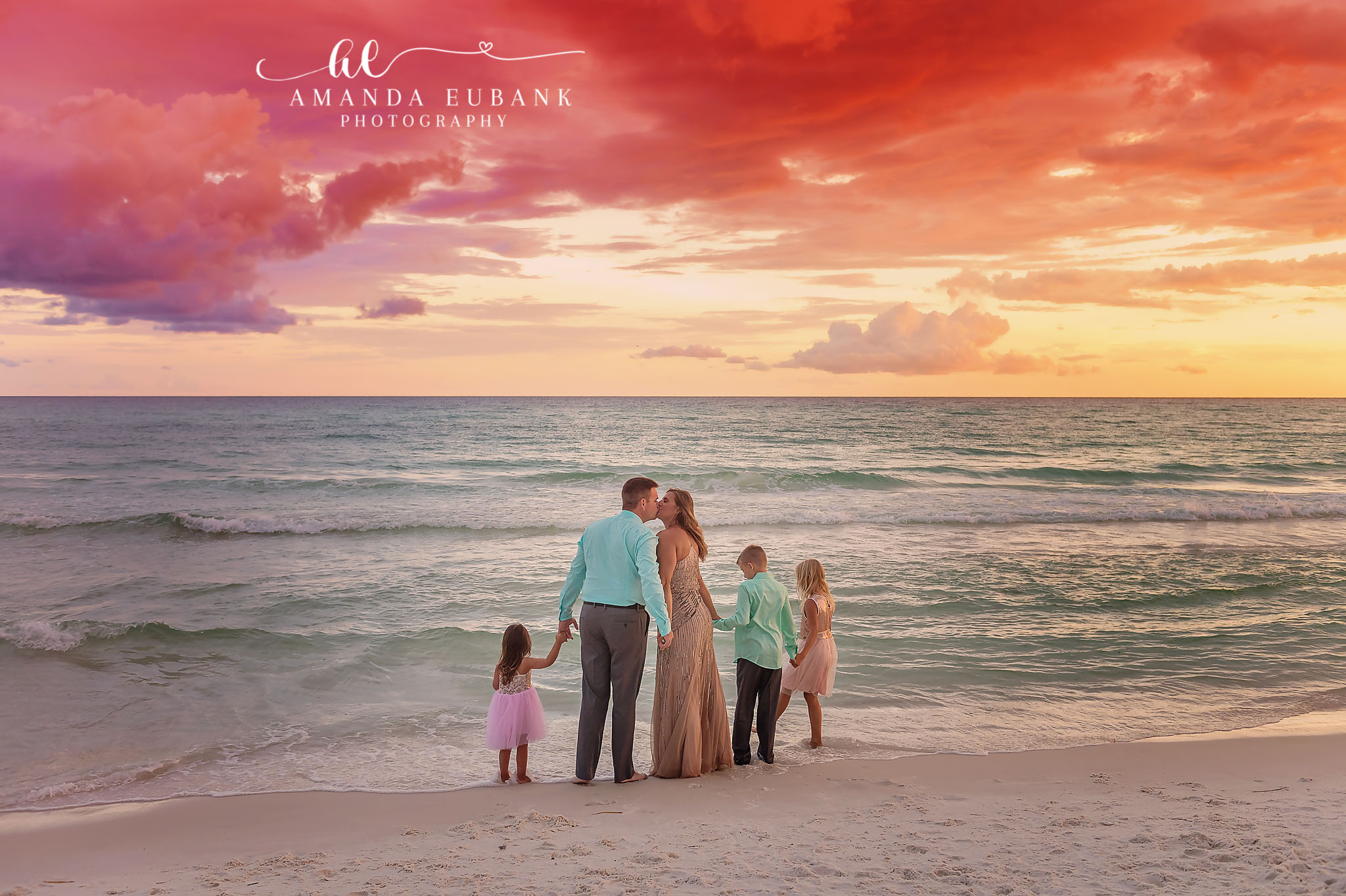 Family Portrait at Dusk | Tampa Beach Family Photography Tampa family photographer captures a family of five standing on the beach as red and purple light fills the sky.
