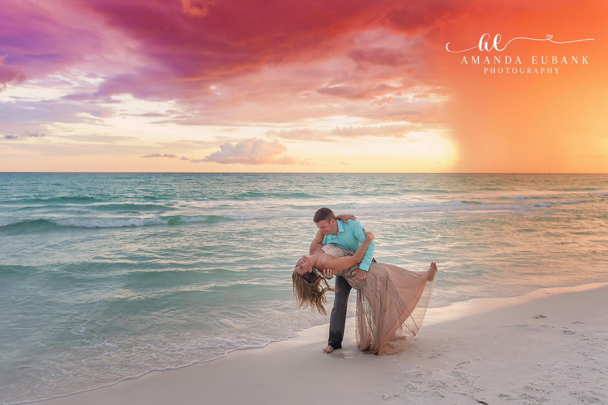 Parents’ Dip Kiss | Couples Photographer in Tampa, Florida Couples portraits in Tampa, FL showing a husband dipping his wife for a kiss on the sand under a teal evening sky.