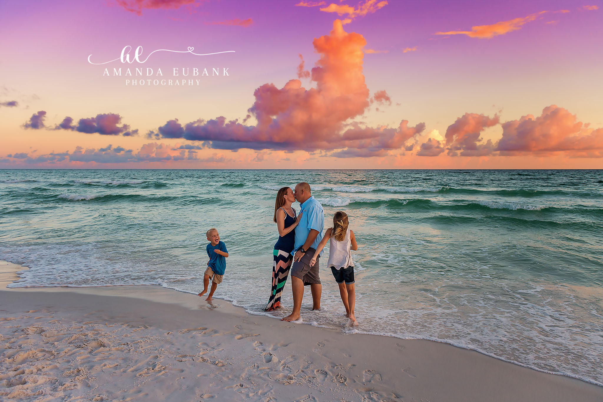Kids Running in the Shallows — Tampa, FL Family Session A family walking in the shallows as the kids run ahead under big sunset clouds at a beach family session near Tampa, Florida.