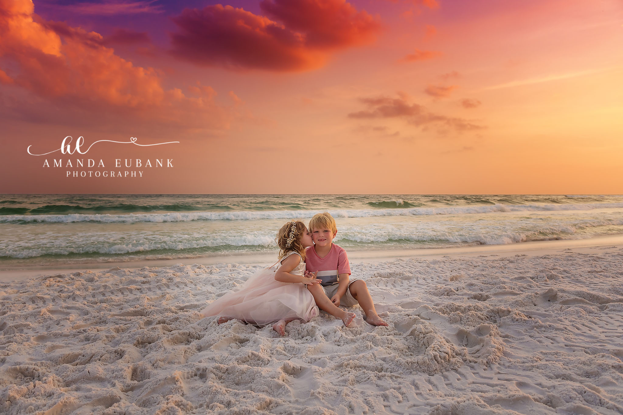 Mother and Toddler in the Shallows — Tampa, FL Family Session A mother and toddler sitting together in the shallow surf under a purple sky at a beach family session near Tampa, Florida.