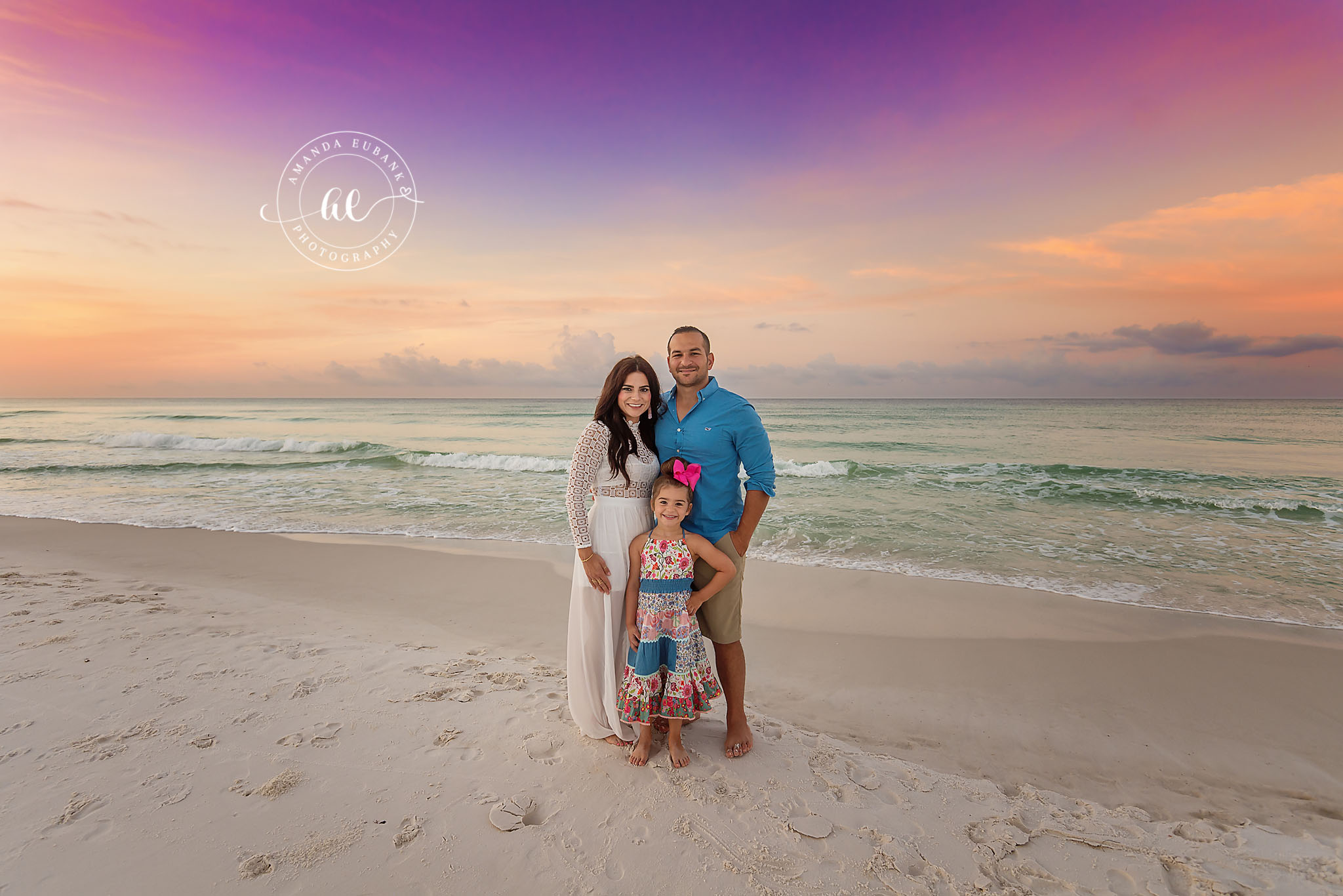 Family of Three on the Beach — Tampa, FL Family Session A family of three standing on the beach with the turquoise Gulf behind them at a beach family session near Tampa, Florida.