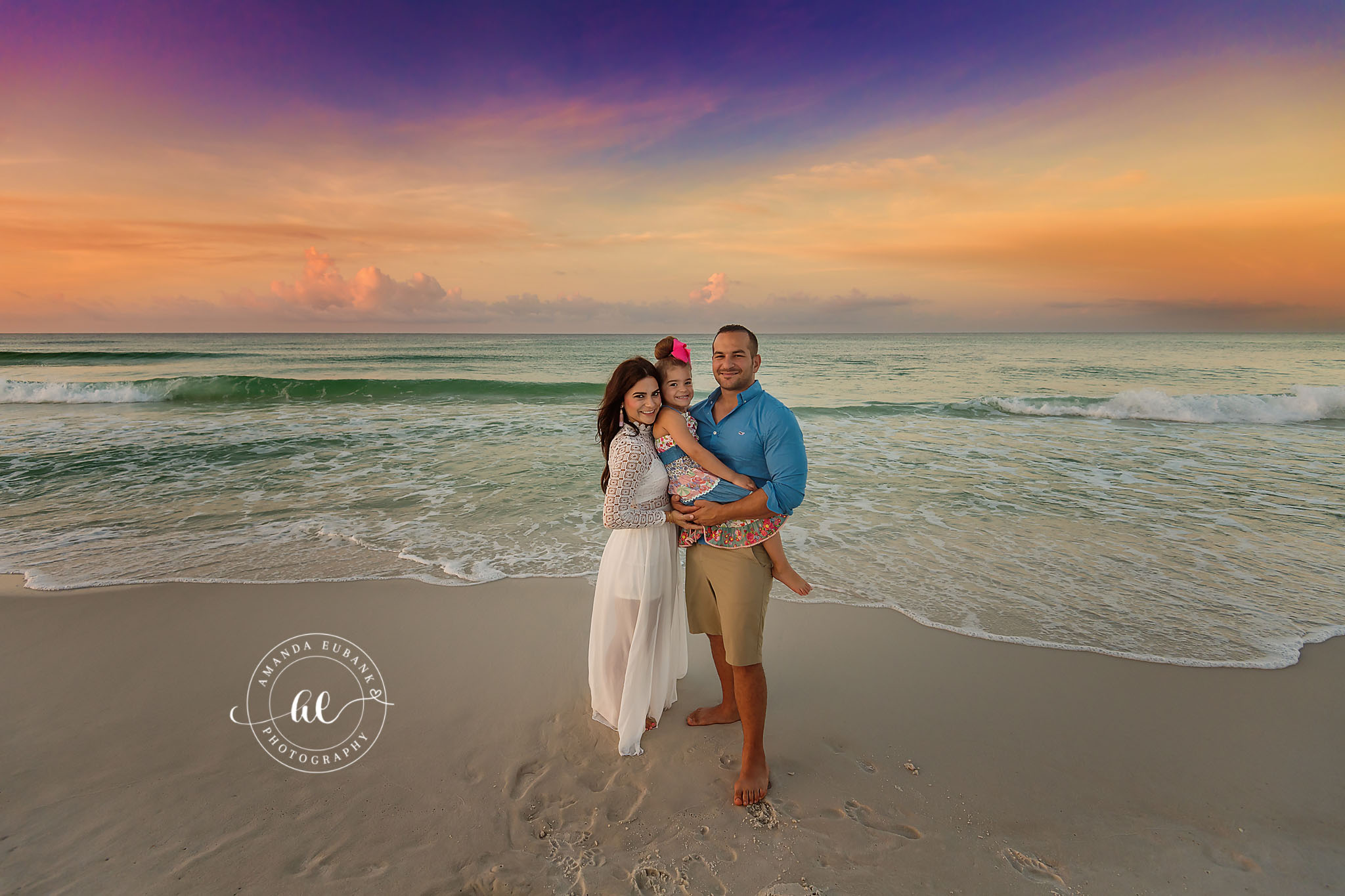 Family of Three on Wet Sand | Tampa Family Photographer A family of three standing on the wet sand under a golden evening sky during a Tampa family photography session.