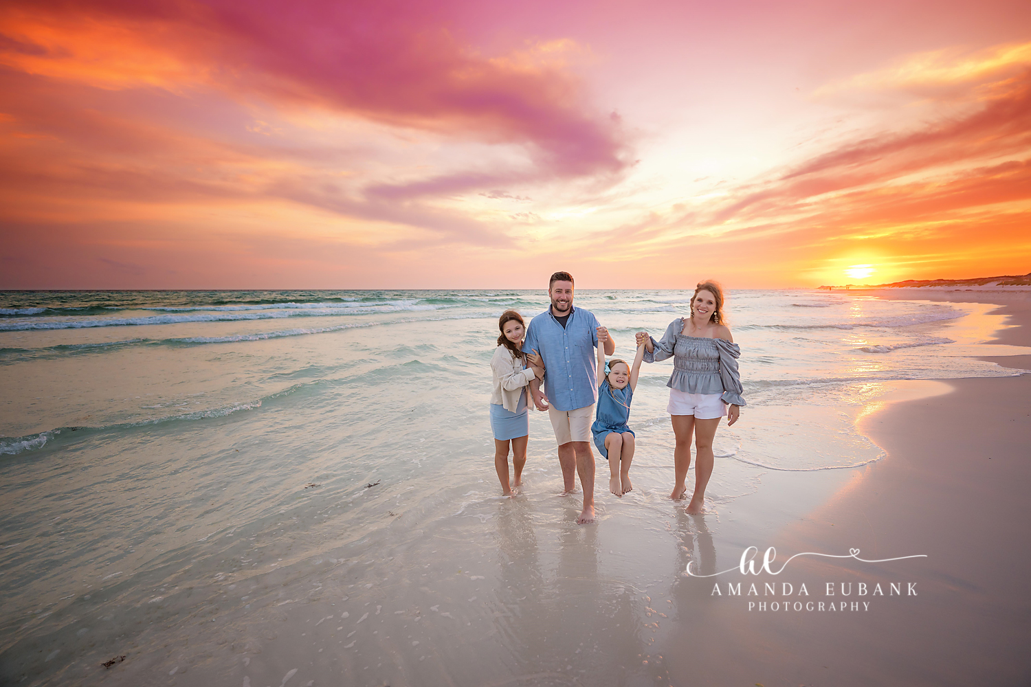 Family Walk Into the Sunset | Tampa Family Photographer A family of five walking hand in hand in the surf as the sun meets the water during a Tampa family photography session.