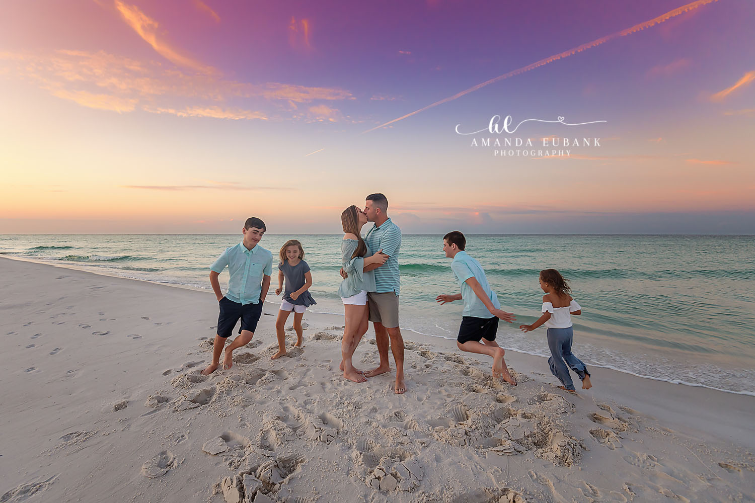 Family Playing on the Beach | Family Photographer in Tampa, Florida Family beach portraits in Tampa, FL showing a family of six playing on the beach as dad lifts the youngest into the air.