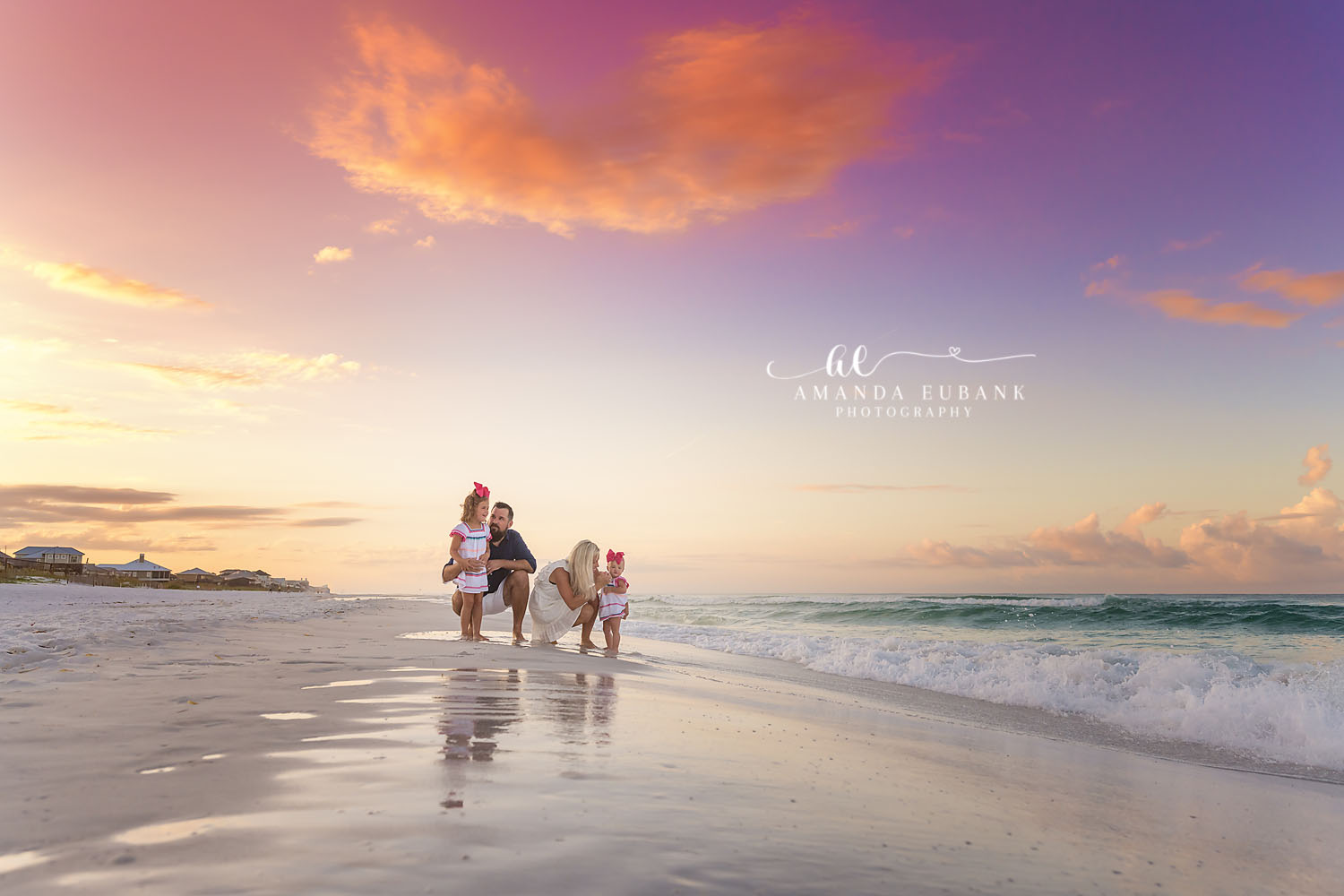 Family and Dog on Wet Sand | Tampa Family Photographer A family walking their dog across wet sand under a wide pastel sunset during a Tampa family photography session.