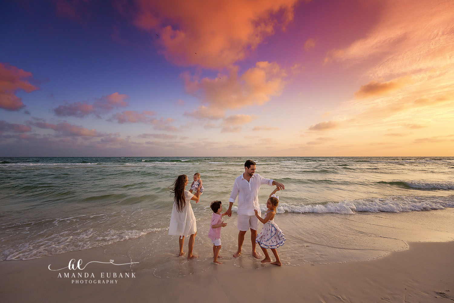 Family Playing at Sunset — Tampa, FL Family Session A family of five playing together on the sand under coral sunset clouds at a beach family session near Tampa, Florida.