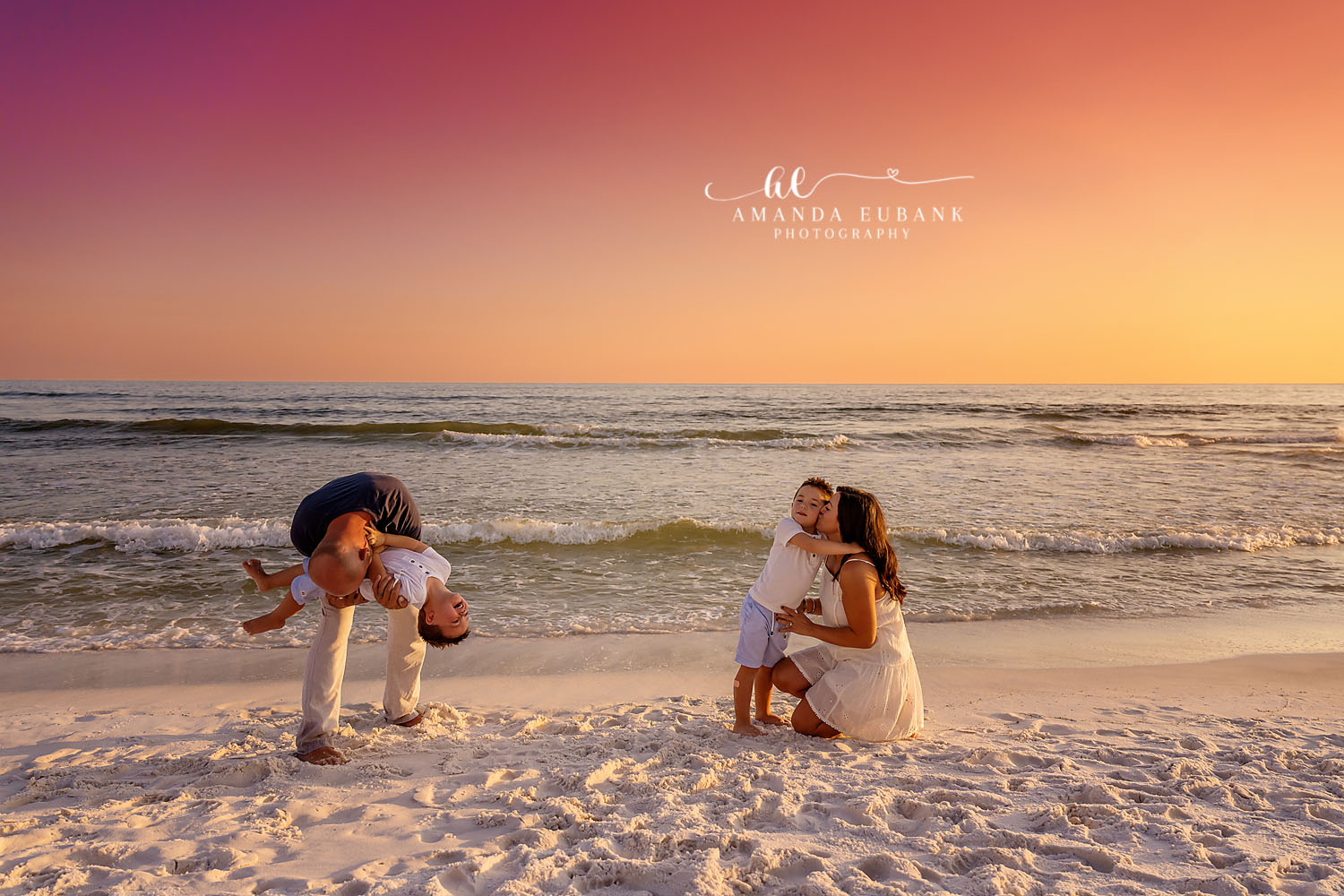 Beach Antics at Golden Hour — Tampa Bay Family Portraits A dad flipping his child on the sand while mom and daughter look on — beach family photography in Tampa Bay.