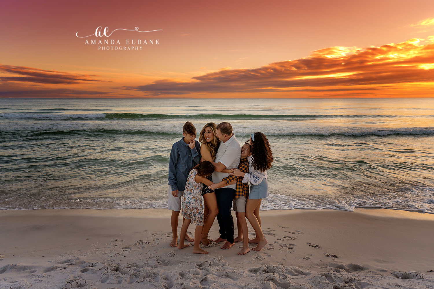Family Group Hug | Tampa Beach Family Photography Tampa family photographer captures a family gathered in a group hug on the beach in warm golden light.