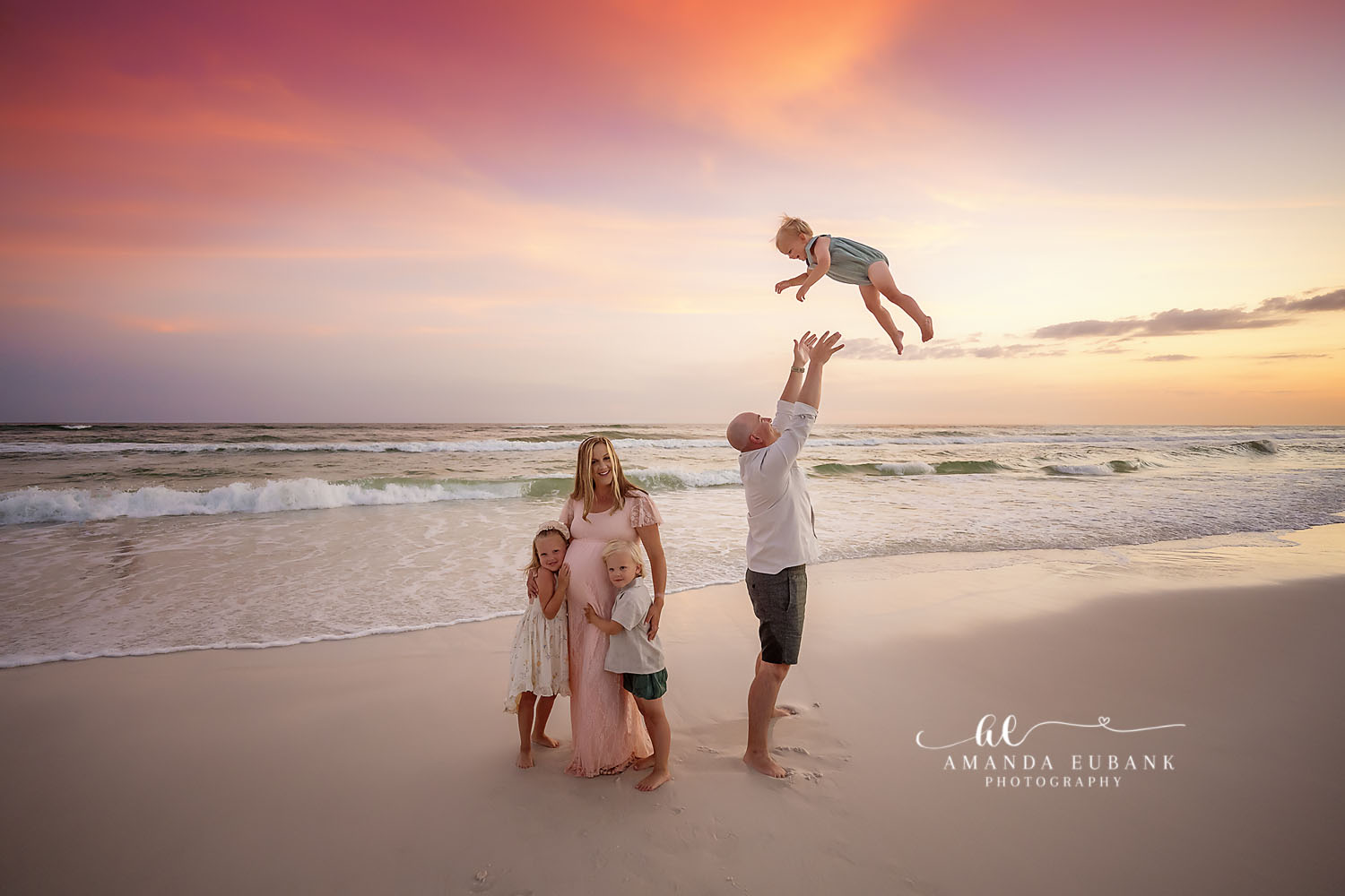 Baby Tossed at Dusk | Tampa Family Photographer A dad tossing his baby into the air while mom and the kids watch at dusk during a Tampa family photography session.