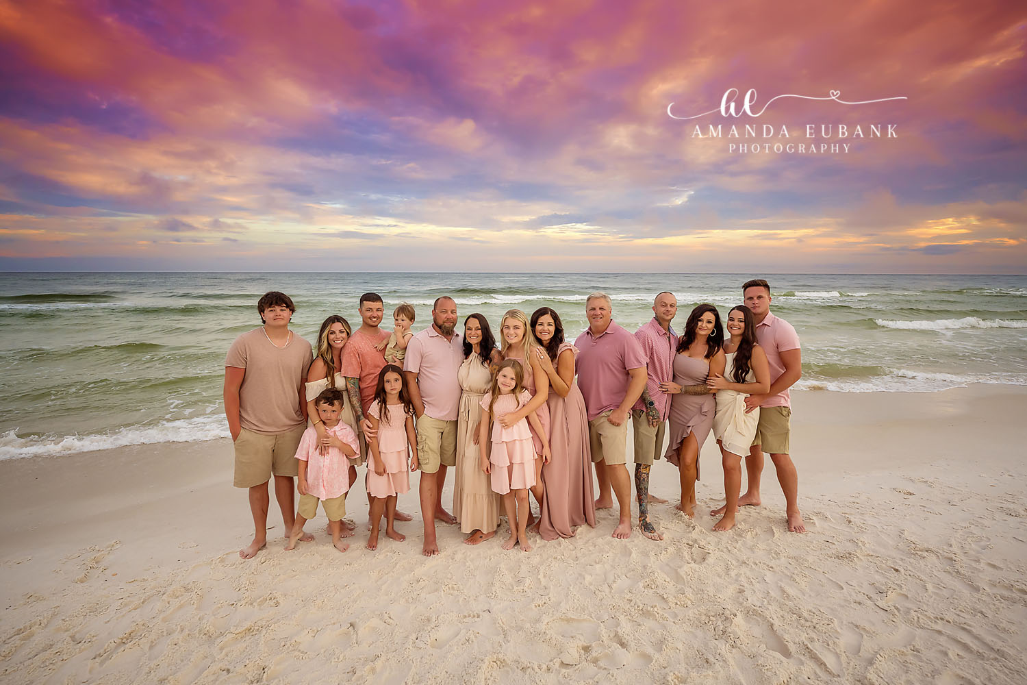 Big Family at Dusk | Tampa Extended Family Photographer An extended family of sixteen standing on the sand in pink and khaki at dusk during an extended family photography session in Tampa, Florida.