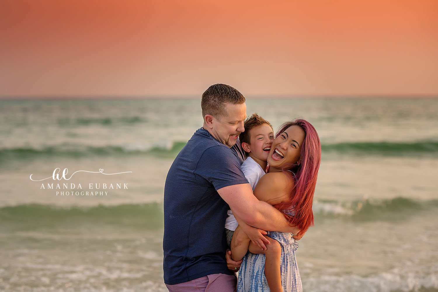 Family of Three Close-Up | Family Photographer in Tampa, Florida Family beach portraits in Tampa, FL showing a close portrait of a family of three with the emerald Gulf behind them.