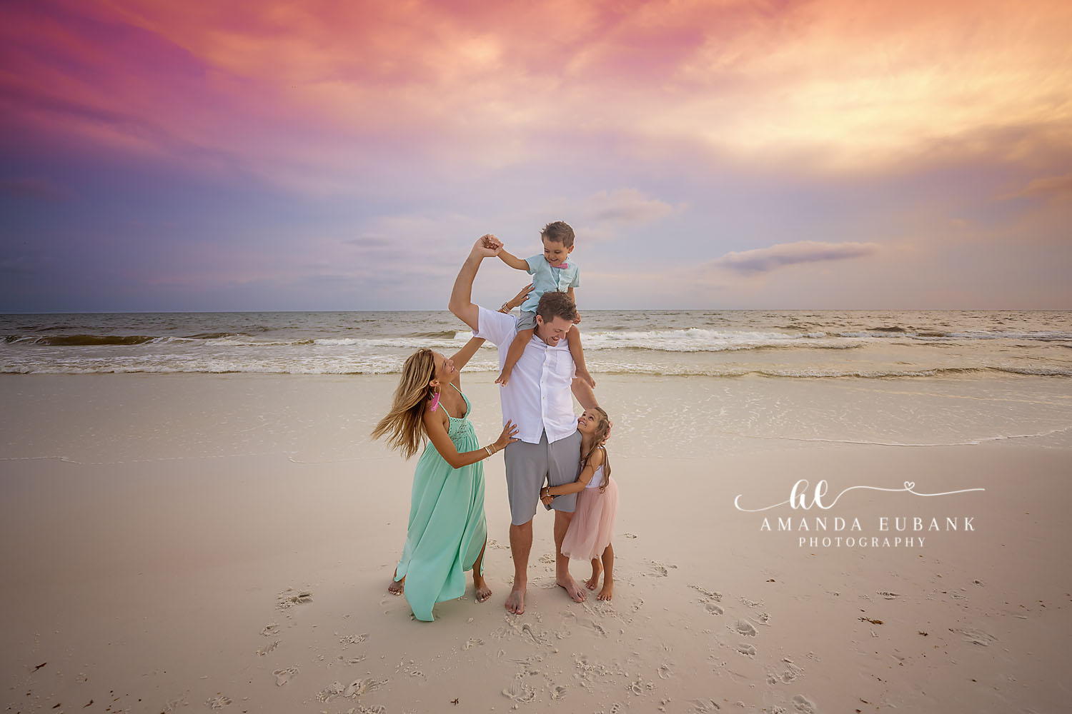 Shoulder Ride at Sunset | Tampa Beach Family Photography Tampa family photographer captures a dad lifting his son onto his shoulders as the family gathers at sunset.
