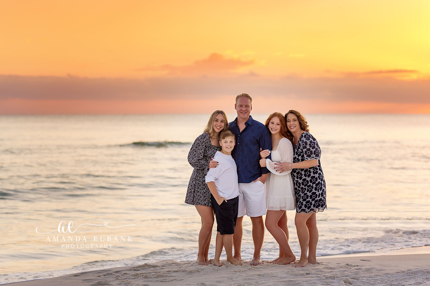 Family of Six in Navy | Family Photographer in Tampa, Florida Family beach portraits in Tampa, FL showing a family of six standing on the shoreline in navy and white at pastel sunset.