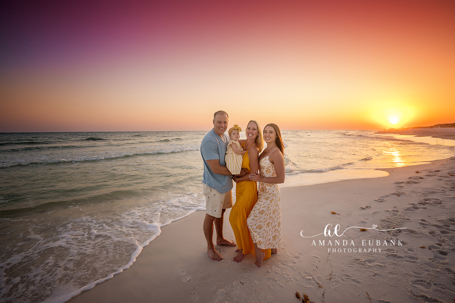 Family at the Sun’s Edge — Tampa, FL Family Session A family of five on wet sand as the sun touches the horizon behind them at a beach family session near Tampa, Florida.