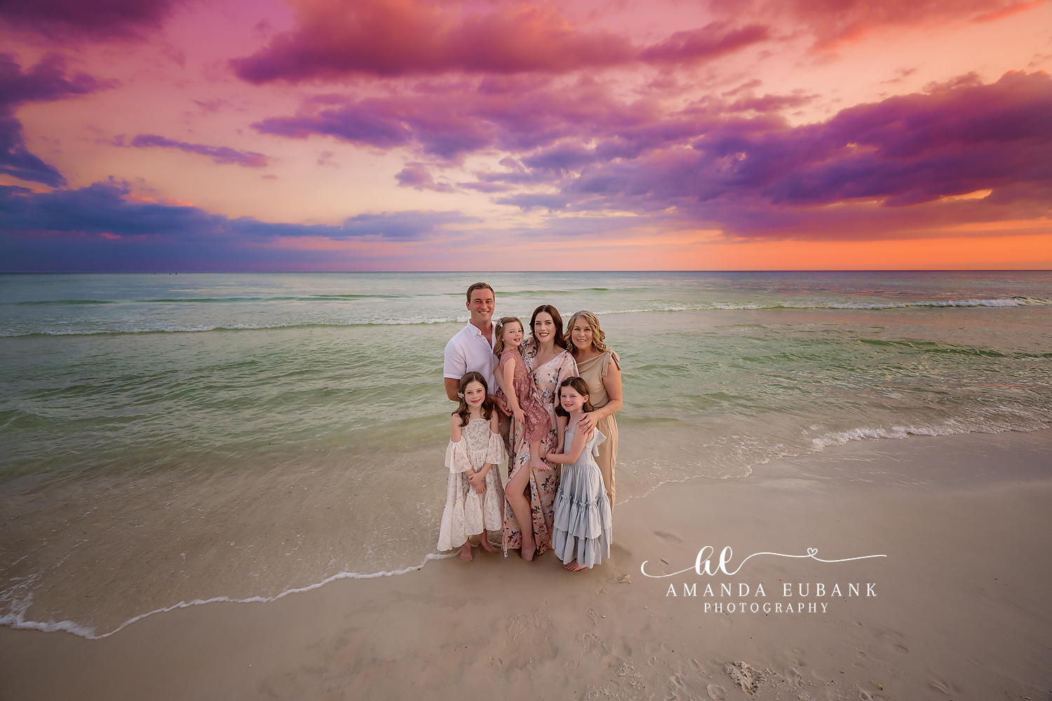 Family of Six at Dusk | Tampa Family Photographer A family of six on the shoreline in blush and cream beneath a violet cloudscape during a Tampa family photography session.