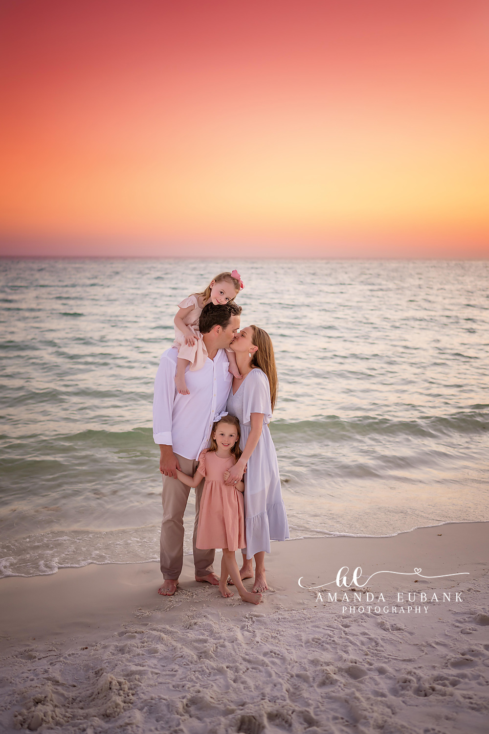 Family in Blush at Dusk | Family Photographer in Tampa, Florida Family beach portraits in Tampa, FL showing a family of four standing on the beach in blush and white at dusk.