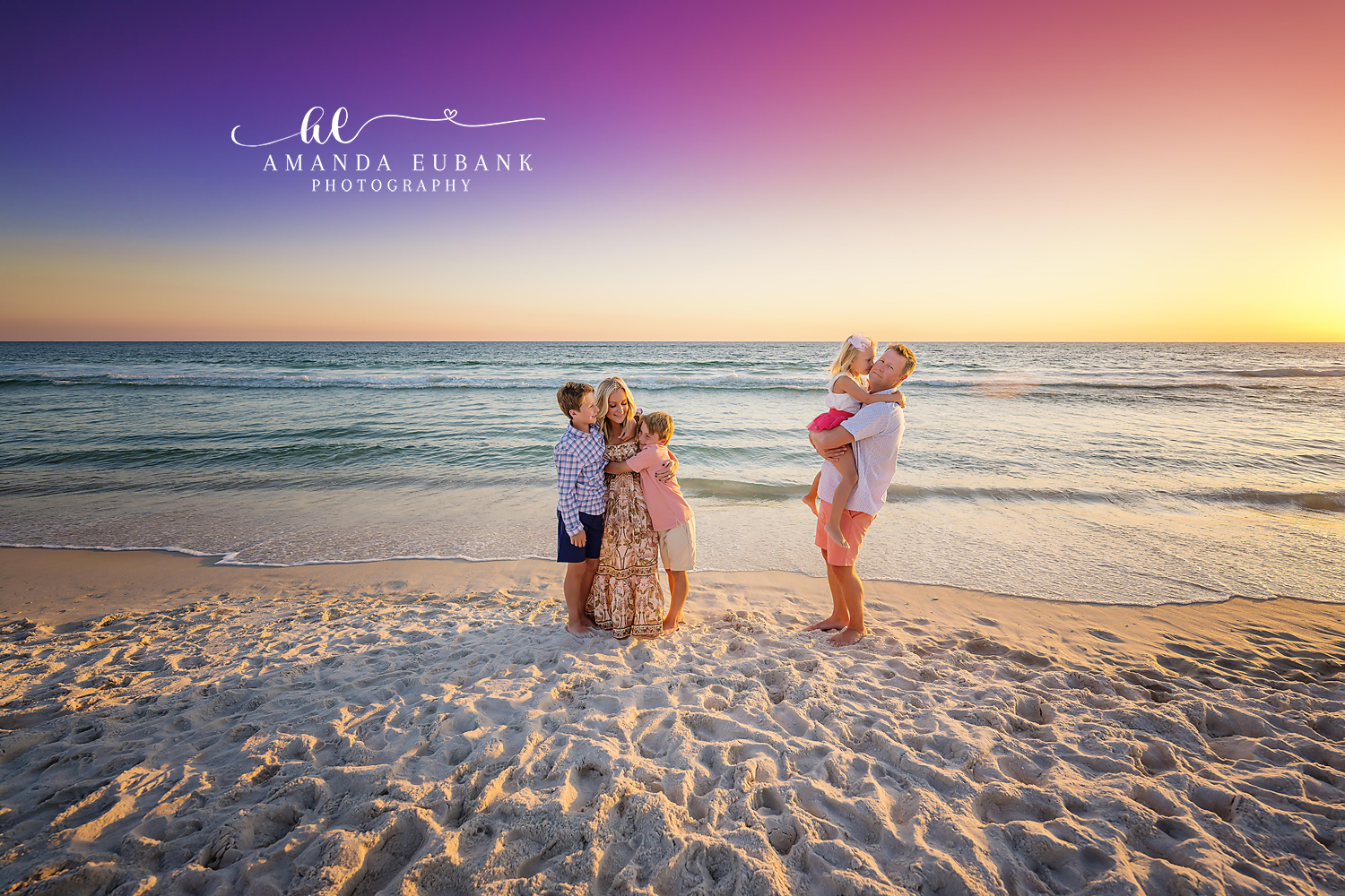 Parents Lifting Their Girls — Tampa Bay Family Portraits Parents lifting their two daughters on the shoreline as the sky glows gold — beach family photography in Tampa Bay.