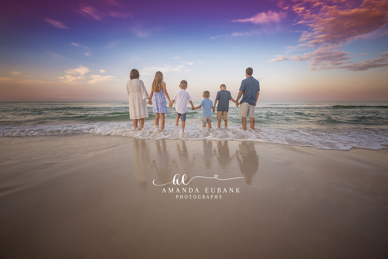 Family Facing the Sea | Tampa Family Photographer A family of seven holding hands in the shallows with their backs to the camera during a Tampa family photography session.