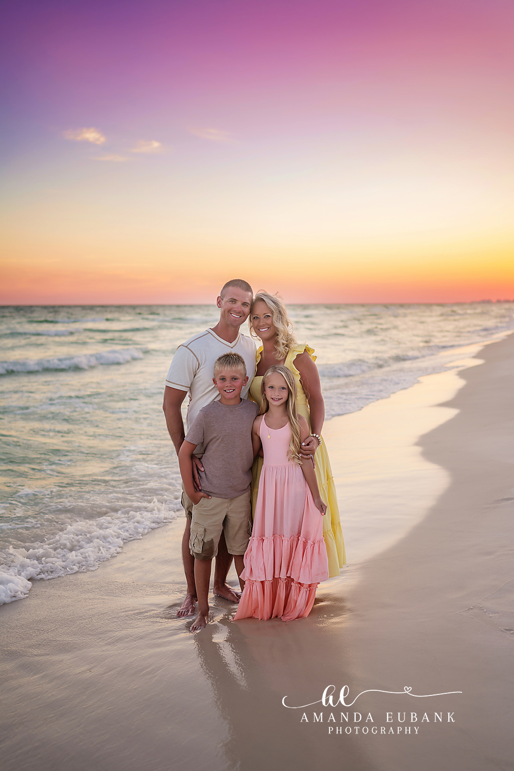 Family of Four at Golden Hour | Tampa Beach Family Photography Tampa family photographer captures a family of four standing on the sand in pink and white as the sun drops low.
