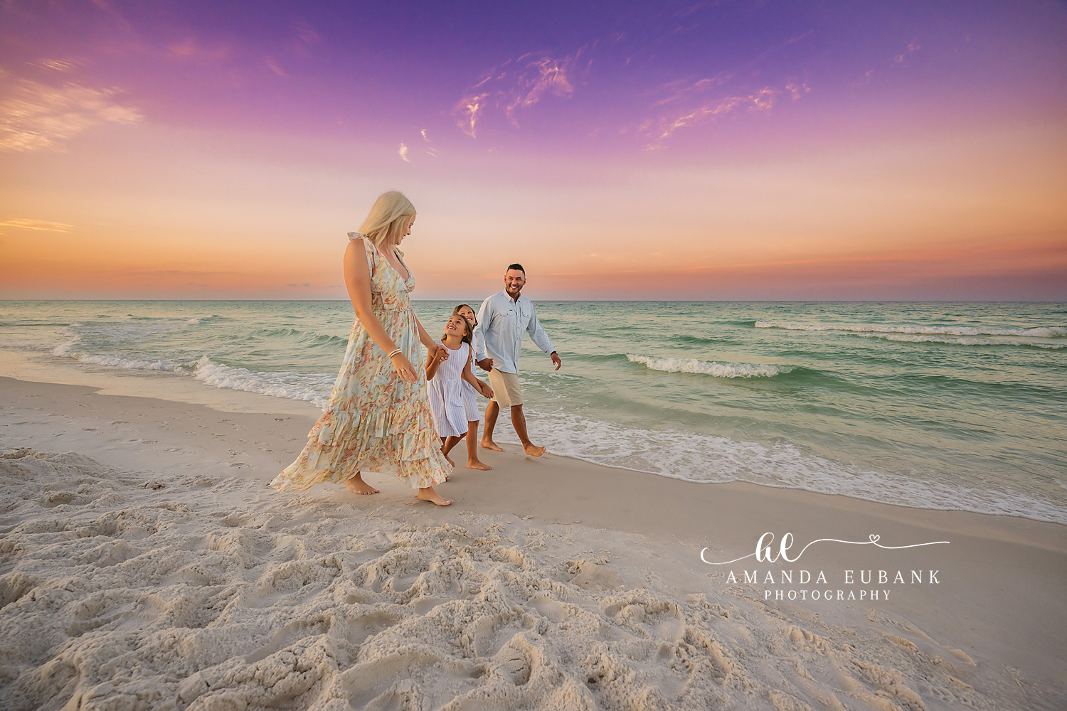 Family Gathered on the Sand — Tampa, FL Family Session A family of five gathered on the sand in yellow and white under a violet sky at a beach family session near Tampa, Florida.